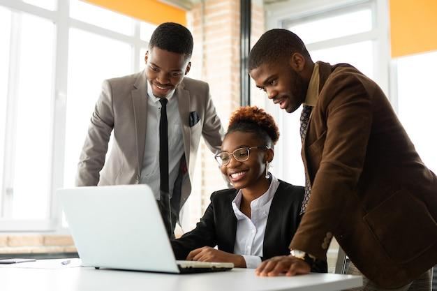 A careers adviser and two graduates reviewing a CV on a laptop